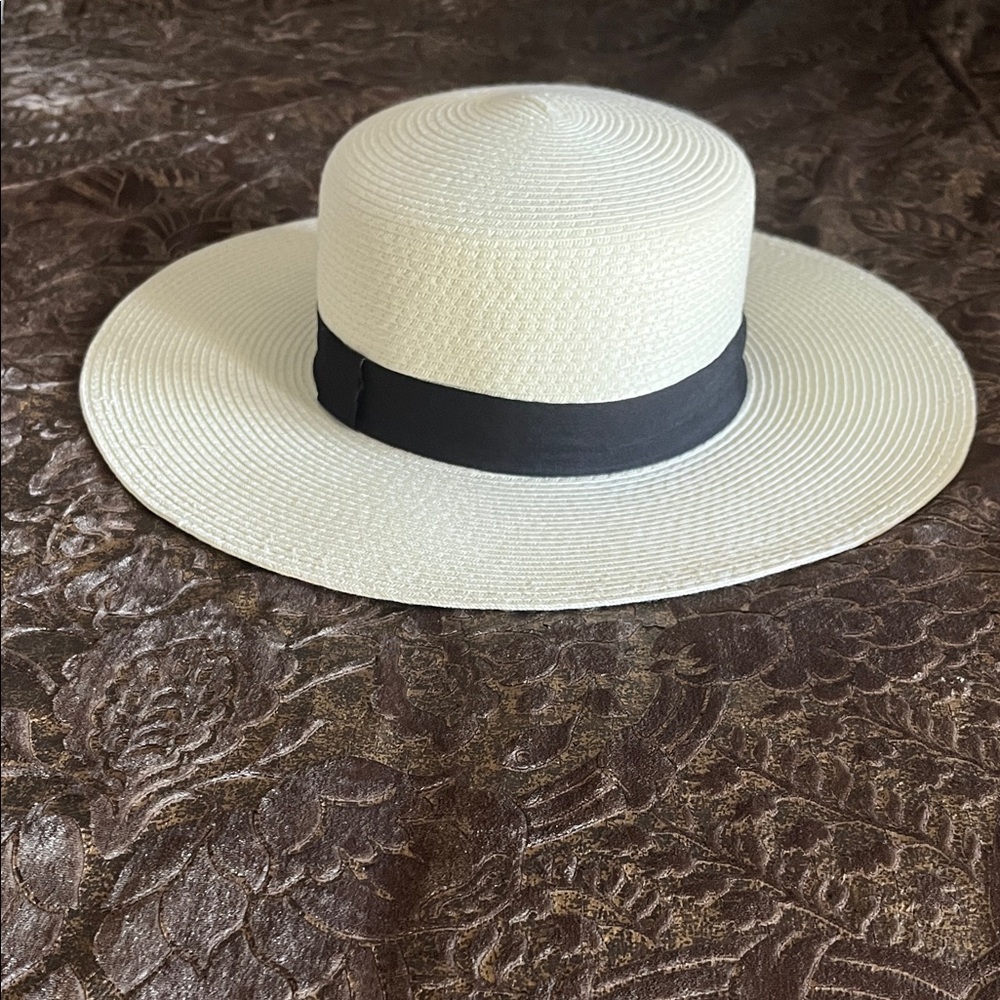 Ladies cream colored hat with black ribbon.